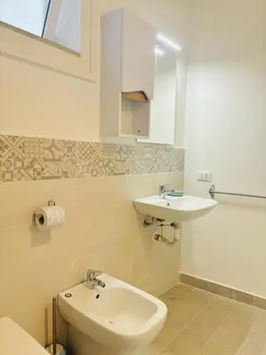 a bathroom with a white toilet and a sink at Calamari37 in Palermo