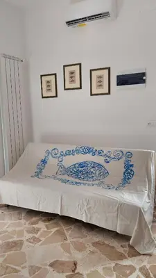 a bed with a blue and white blanket on it at La casa di Gisa&Laura Lido di Mondello spiaggia in Palermo