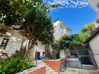 a house with a tree in front of a building at La casa di Gisa&Laura Lido di Mondello spiaggia in Palermo