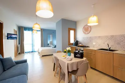 a kitchen and living room with a table and a couch at Casa vacanze near airport in Cinisi