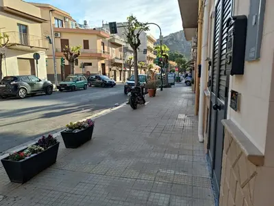 a city street with flowers inpots on the sidewalk at Lannari 176 Casa vacanze Bagheria in Bagheria
