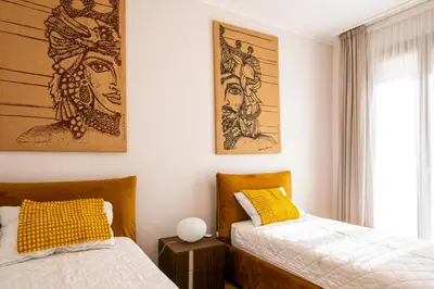 a bedroom with two beds and a painting on the wall at Casa Alexandra - Luxury & Design in Castellammare del Golfo