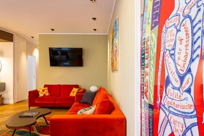 a living room with a red couch and a table at Casa Alexandra - Luxury & Design in Castellammare del Golfo