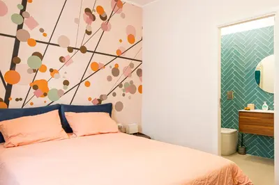 a bedroom with a bed with a flower mural on the wall at Casa Alexandra - Luxury & Design in Castellammare del Golfo