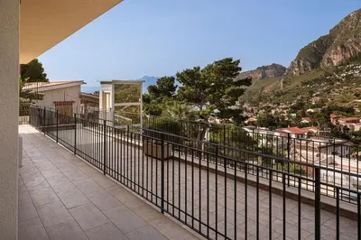 a balcony with a view of a city and mountains at Capo Zafferano Apartments in Santa Flavia