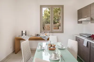 a kitchen with a table and chairs in a kitchen at Capo Zafferano Apartments in Santa Flavia