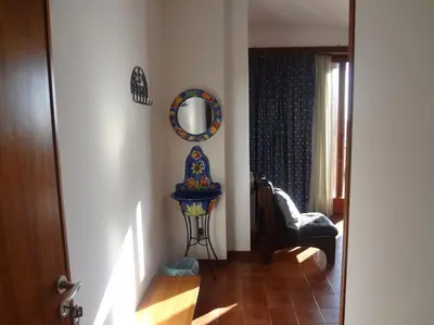 a living room with a mirror and a chair at Casa Riccio in Palermo