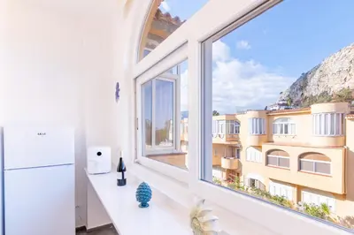 an apartment with a large window with a view of a building at Sofia’s Studio at Mondello in Palermo