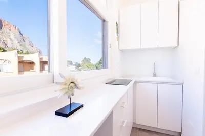 a kitchen with white cabinets and a window at Sofia’s Studio at Mondello in Palermo
