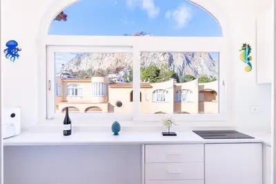 a kitchen with a window with a mountain view at Sofia’s Studio at Mondello in Palermo