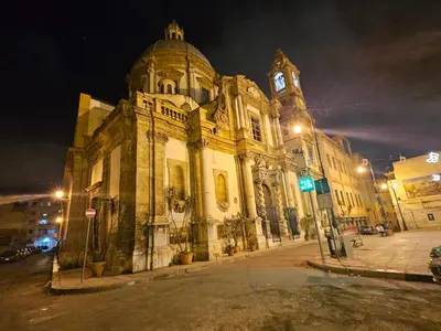 an old building with a clock tower at night at Terrazza Ballarò in Palermo