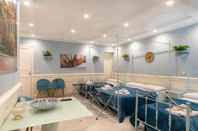 a room with four beds and a table and chairs at Federico 70 Acquamarina Luxury in Palermo