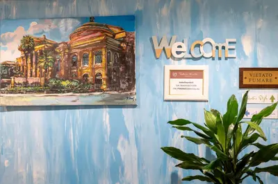 a painting on a blue wall with a plant at Federico 70 Acquamarina Luxury in Palermo