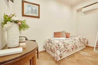 a bedroom with a bed and a table with a vase of flowers at Villa laura in Palermo