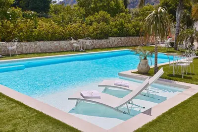 a swimming pool with two lounge chairs and a table at Villa laura in Palermo