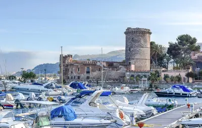 a bunch of boats in a harbor with a castle at Lovely Home In Altavilla Milicia in Altavilla Milicia
