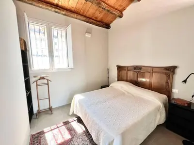 a bedroom with a bed with a wooden headboard and a window at Loft Palermo Centro con terrazzo. Free parking in Palermo