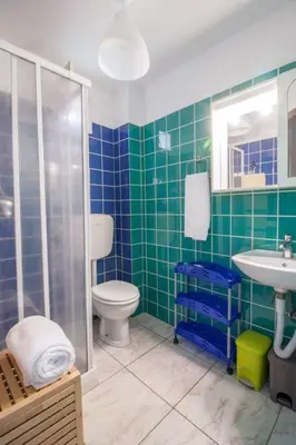 a green tiled bathroom with a toilet and a sink at Appartamento del centro CIR 19081005C217988 in Castellammare del Golfo
