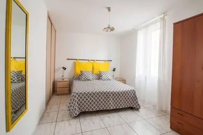 a bedroom with a bed with yellow pillows at Appartamento del centro CIR 19081005C217988 in Castellammare del Golfo