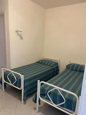 two beds in a small room withthritisthritisthritisthritisthritisthritisthritisbestosbestos at Turisti a Casa in San Vito lo Capo