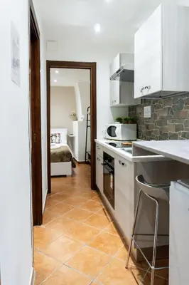 a kitchen with white cabinets and a tile floor at Quattro canti apartment Palermo centro storico in Palermo