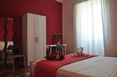a bedroom with a bed with a red wall at B&T Holiday House in Palermo