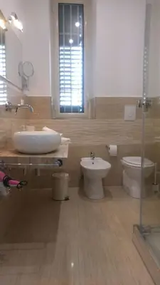 a bathroom with a sink and a toilet and a mirror at B&T Holiday House in Palermo