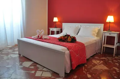 a bedroom with a bed with a red wall at B&T Holiday House in Palermo