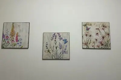 four paintings of flowers on a white wall at Lilla' House Center Palermo in Palermo