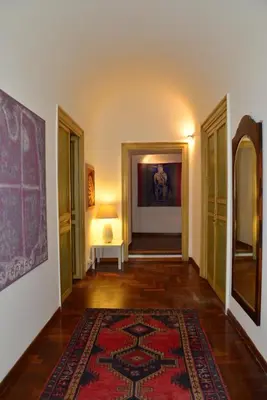 a hallway with a rug and a table and a lamp at La Locanda dei Corrieri in Palermo
