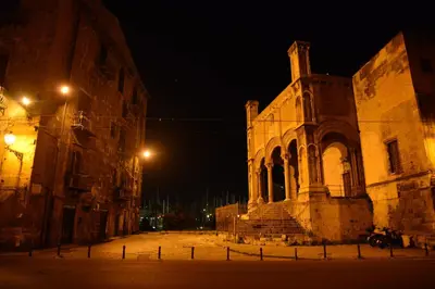 an old building with a clock tower at night at La Locanda dei Corrieri in Palermo