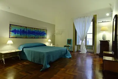 a bedroom with a bed with a blue bedspread at La Locanda dei Corrieri in Palermo