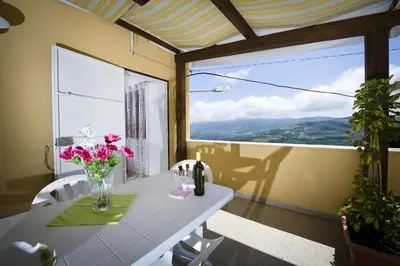 a dining room with a table with flowers on it at Casa Vacanza Saraceno in Castellammare del Golfo