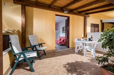 a patio with chairs and a table and a dining room at Casa Vacanza Saraceno in Castellammare del Golfo