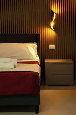 a bedroom with a bed and a light on a wall at Sicily Luxury Rooms in Palermo