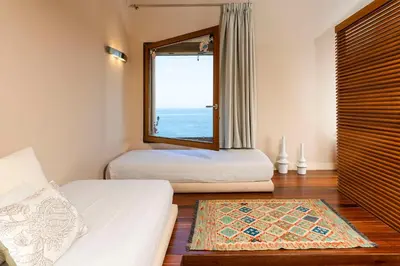 a bedroom with two beds and a large window at Casa del Rais con accesso privato al mare in Santa Flavia