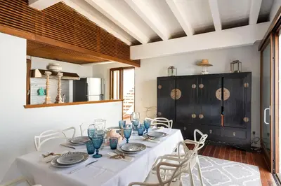 a dining room with a white table and chairs at Casa del Rais con accesso privato al mare in Santa Flavia