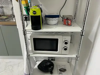 a microwave on a shelf in a kitchen at Casa Maria Rosa Semplice in Palermo