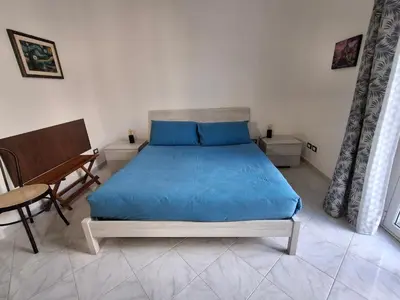 a bedroom with a bed with blue sheets and a piano at Casa Maria Rosa Semplice in Palermo