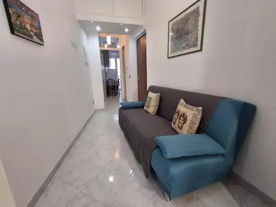 a living room with a couch and a blue chair at Casa Maria Rosa Semplice in Palermo