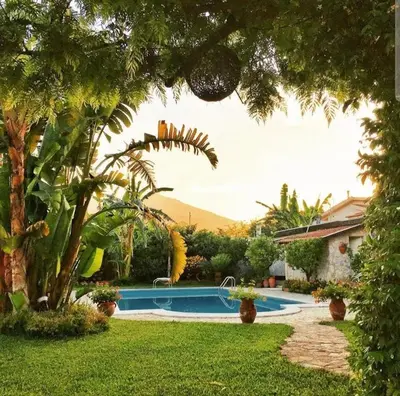 a garden with a swimming pool and a house at Casa Lucale in Palermo