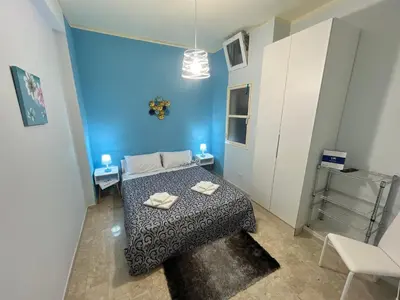 a small bedroom with a bed and a blue wall at Sweet Home Pietro e Lia by Holiday World in Casteldaccia