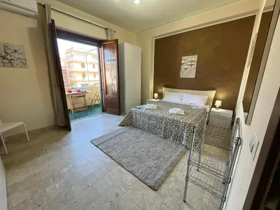 a small room with a bed and a balcony at Sweet Home Pietro e Lia by Holiday World in Casteldaccia