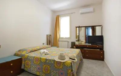 a bedroom with a bed with a hat and a mirror at Nice Apartment In Portella Di Mare in Portella di Mare