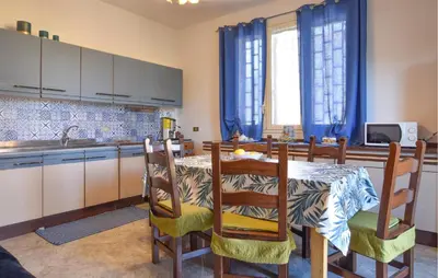 a kitchen with a table and chairs in a kitchen at Nice Apartment In Portella Di Mare in Portella di Mare