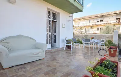 a white couch on a patio with a table and chairs at Nice Apartment In Portella Di Mare in Portella di Mare