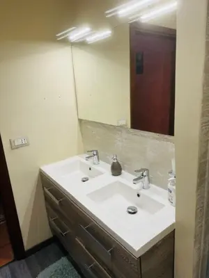 a bathroom with a sink and a large mirror at L'abete in Villabate
