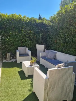 a patio with two chairs and a couch and a table at Marina Mondello House comfort in Mondello