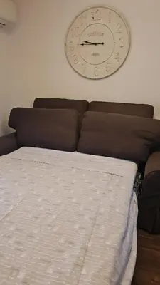 a clock hanging on a wall above a bed at Marina Mondello House comfort in Mondello