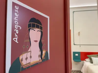 a painting of a woman on a wall in a room at Le Dame di Sicilia Sicilian Vintage Rooms in Palermo